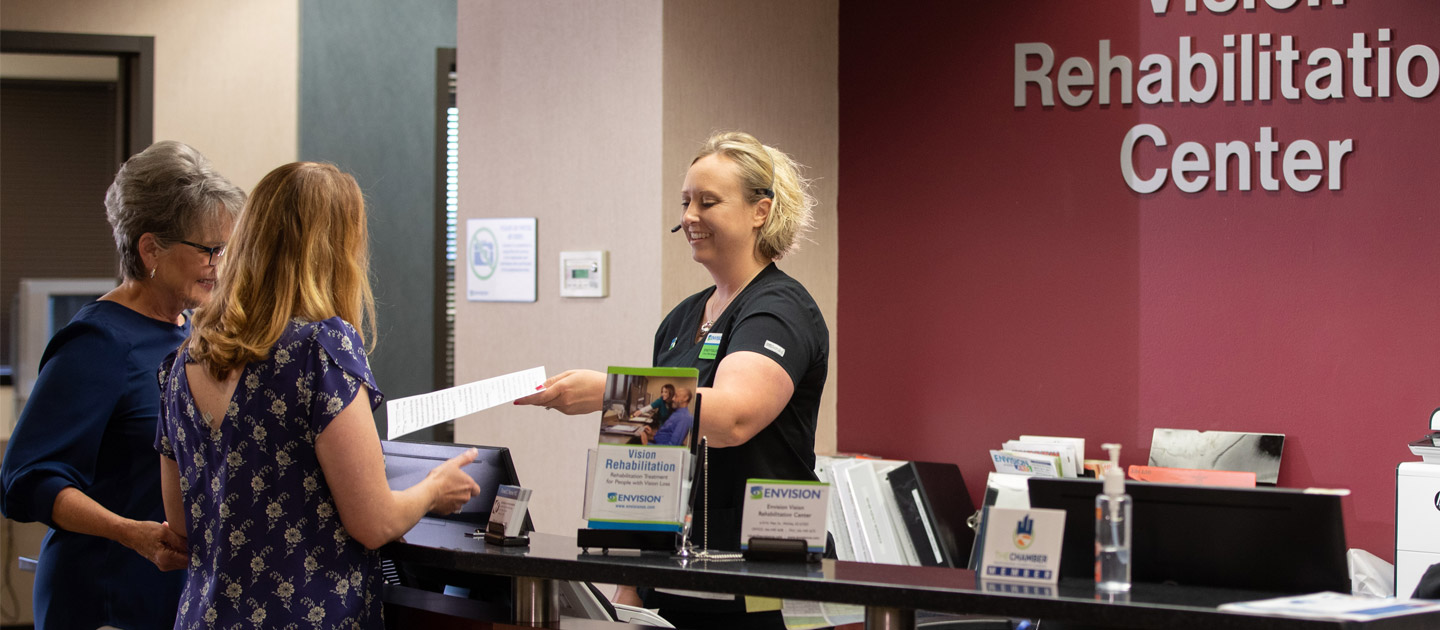 A patient submits paperwork for her appointment at the Envision Vision Rehabilitation Center.