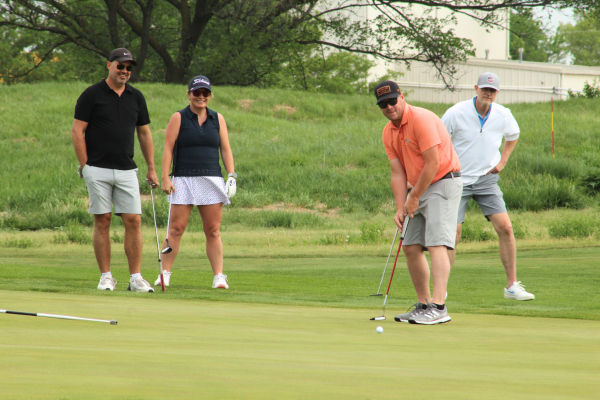 A group of four golfers on the green.