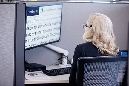 A female envision employee sitting at a computer working. 