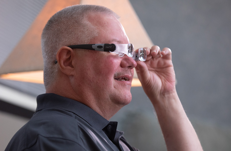 Man trying on optical glasses with magnification