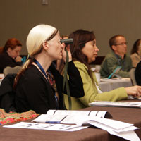 Group of professionals listen to a speaker at an Envision University conference.