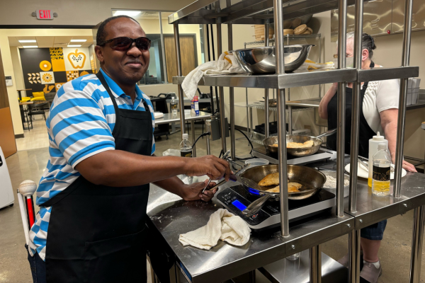Envision & NICHE Launch Culinary Classes for People with Vision Loss Johnson Riungu, Envision employee, cooking in the kitchen at NICHE.