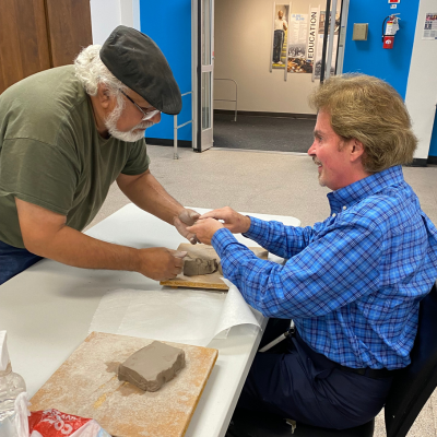 Blake Lindsay, Envision Dallas Outreach Manager learning sculpting techniques from Tomas Bustos.