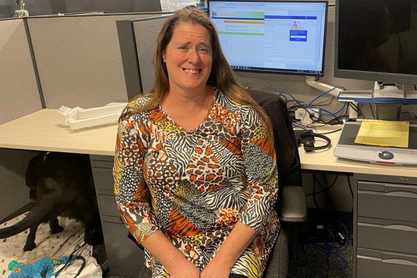 Sandy sitting at a desk smiling.