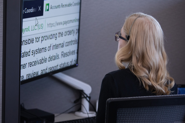 Free Assistive Technology & Career Ready Training Hosted by the Envision Workforce Innovation Center A visually impaired woman sitting at a desk reading zoom text on a computer screen.