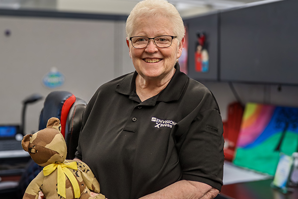 35 Years of Purpose: Wanda’s Envision Legacy Wanda holding a bear created with military fabric from Envision.