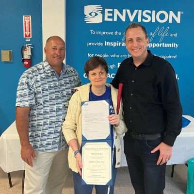 David Stupay standing with Envision President and CEO Michael Monteferrante presenting an award to an Envision Dallas employee.