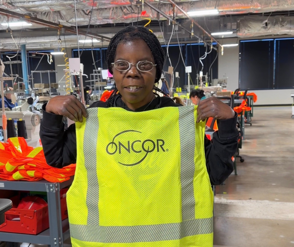 Kimberly Bunch, Envision Dallas employee, holds up the new Oncor yellow vest