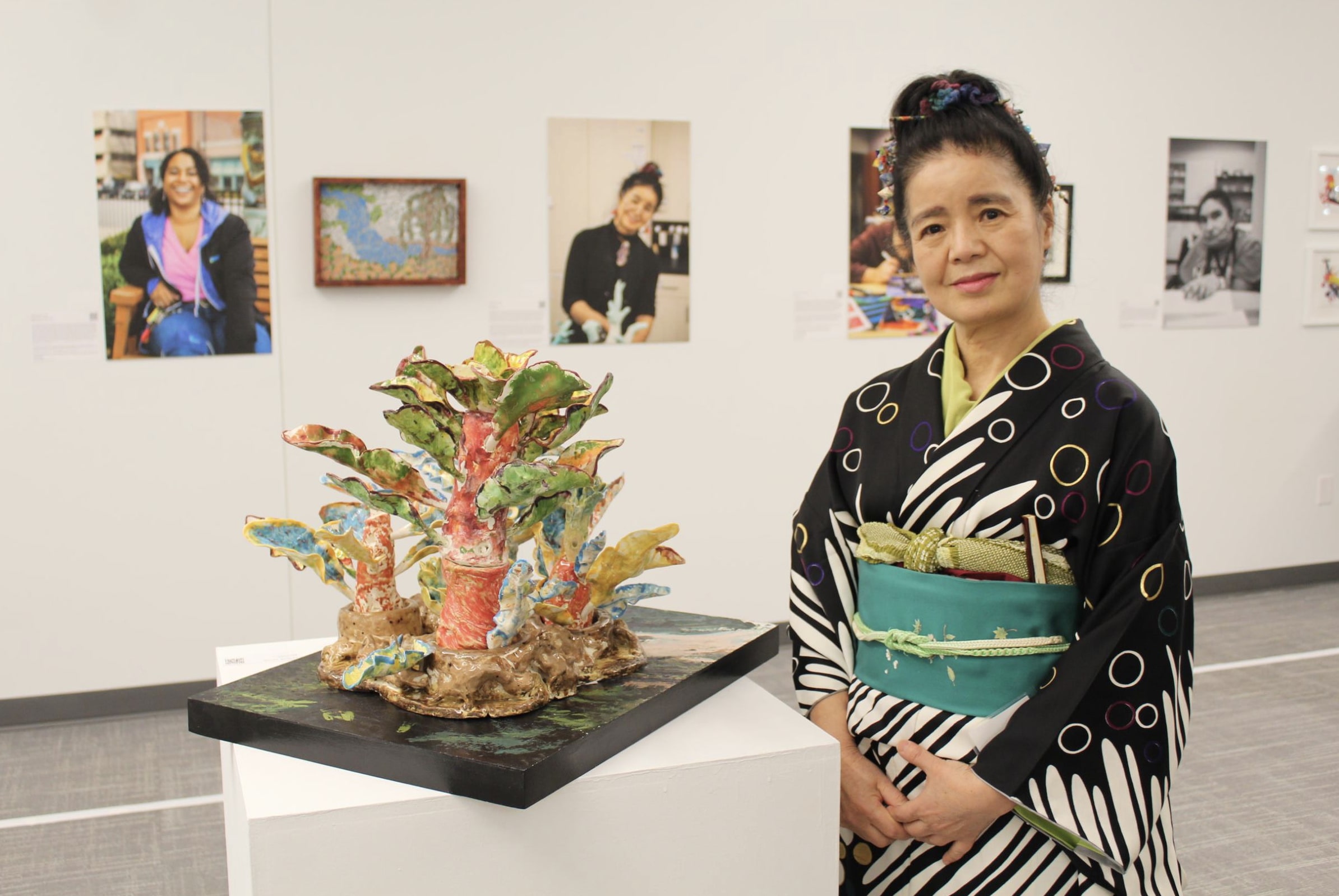 BVI Artist Tomiyo Tajiri poses with her 3D ceramic sculpture depicting a Japanese landscape.