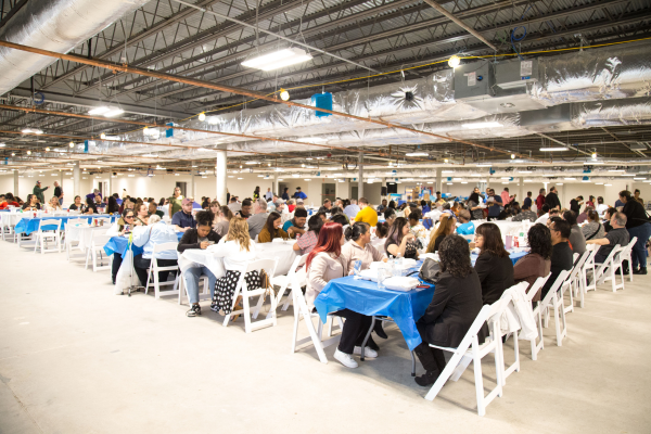Around 200 people sitting at lunch tables inside the new building.