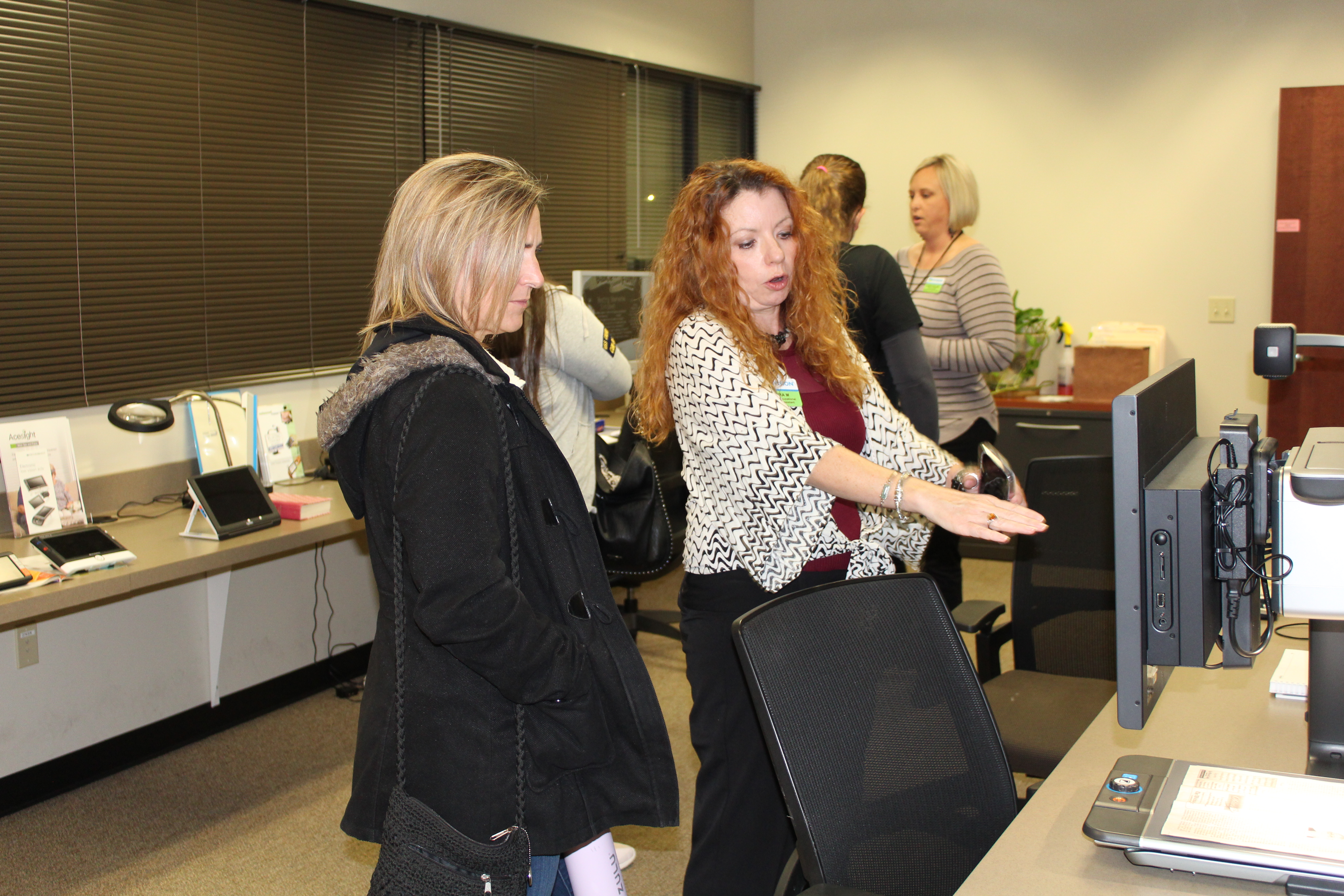 OT assistant explains one of the assistive devices at the EVRC open house