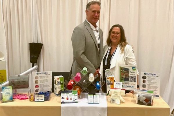SourceAmerica National Conference - More Opportunities for Envision Industries Buddy Sell and Kathy Vines at their Envision booth, smiling at the camera.