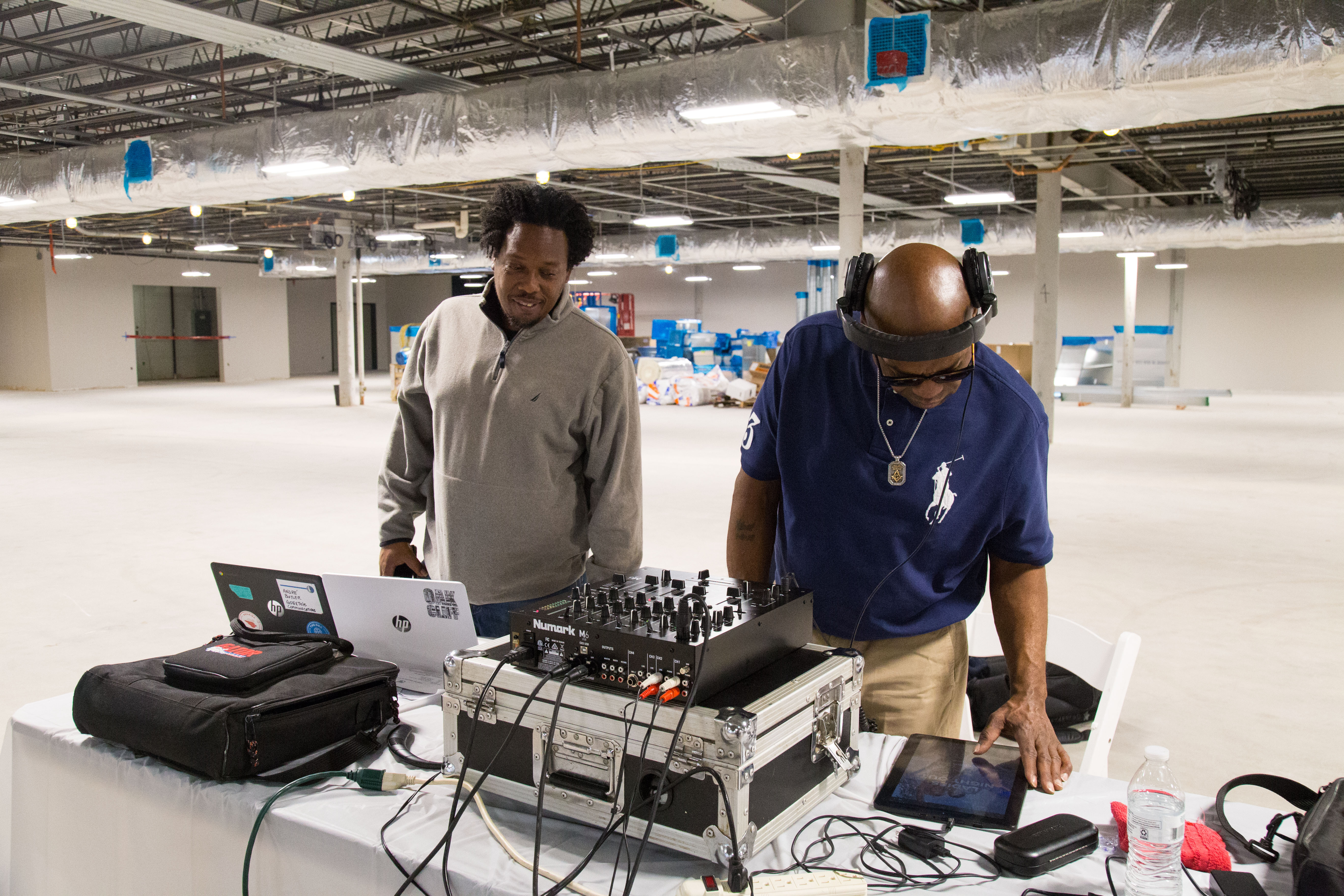 Two people Dj'ing at a table.