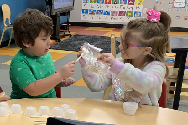 Benjamin Watts and Valynn Walterscheid building a shelter for winter animals during craft time.