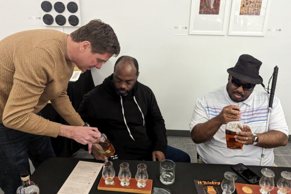 Justin Ladner, Envision donor, participated in the workshop, is pictured above, explaining the whiskey to Charles and Brandon, Envision employees..
