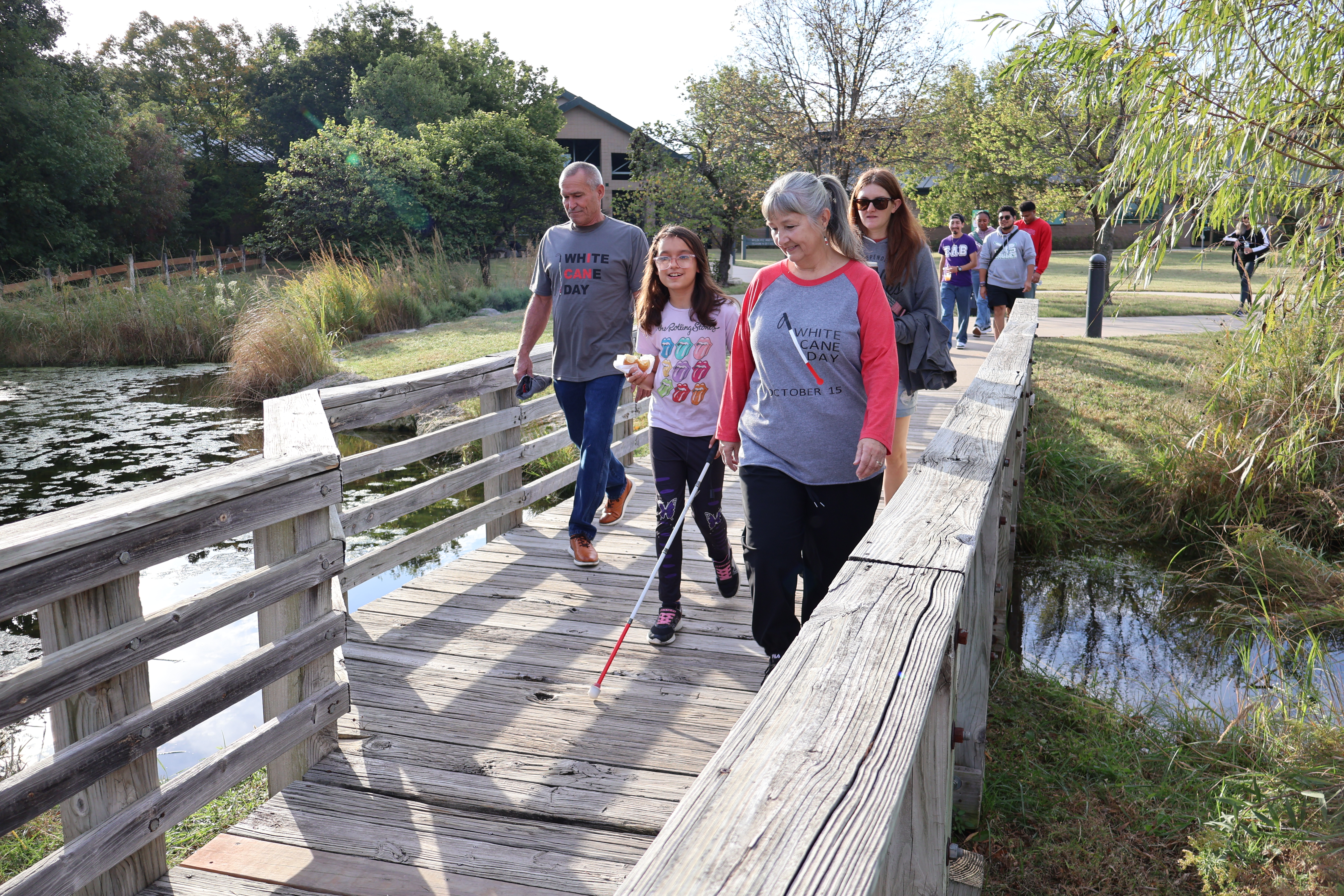 A group walking across a bridge together at the Wichita White Cane Day Walk