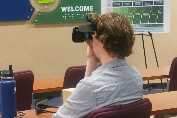 Jeremy using a VR device sitting at a table.
