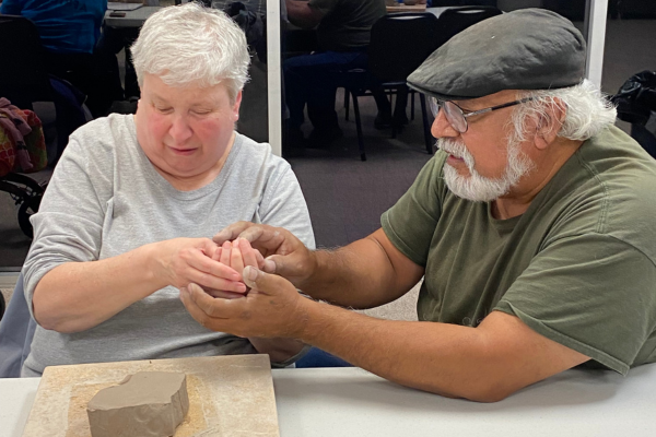 Growth in Dallas Brings Art To More People With Visual Impairments Tomas Bustos helps an Envision Dallas art student mold clay.