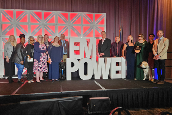 NDEAM and "Empower" Focuses of 2023 NIB/NAEPB Conference Expo All four employees of the year, plus ones and Envision leaders standing on stage smiling.