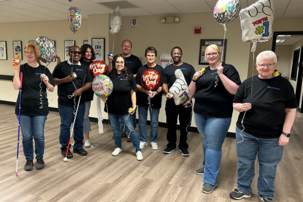 The customer service team in Wichita standing together and smiling.