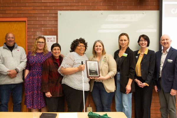Michael Monteferrante, Noreen Carrocci, Emily Hurst, Hannah Christenson, Teresa Houston and Sarah Kephart standing with members of WSU CAS faculty, all smiling at the camera as Teresa holds the award plaque. 