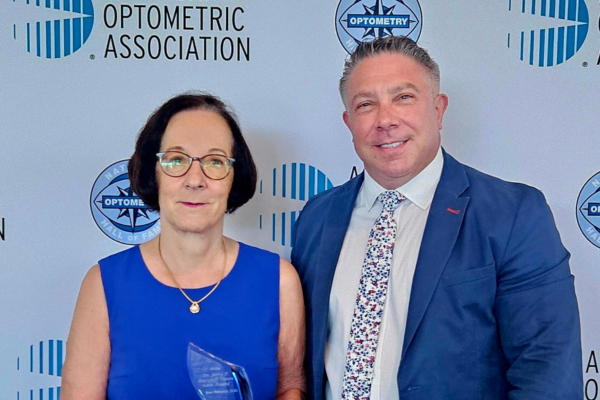 Envision University Honors Leaders in Vision Care at 2024 AOA Conference Lou standing with Joan Stelmack as she holds her award.