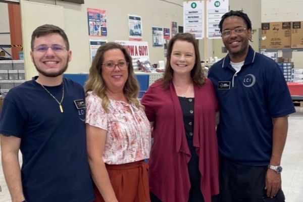 Envision Industries Shines Nationwide with Key Trade Shows Kathy Vines and Clara Nichols standing with two other vendors, smiling at the camera.