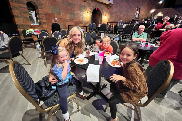 A group of kids eating pizza at a table.
