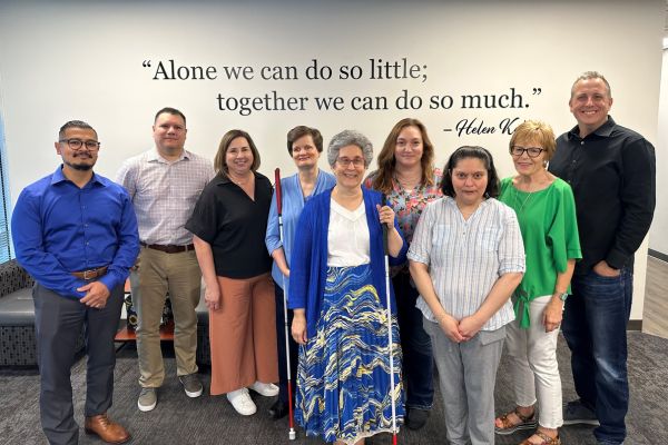 A group of Envision Interface employees standing with David Stupay and Heather Moore, all smiling.