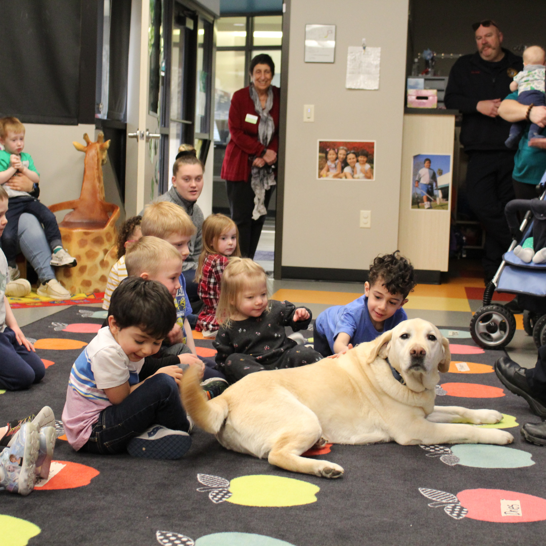 Buddy the tracking dog being petted by the children.