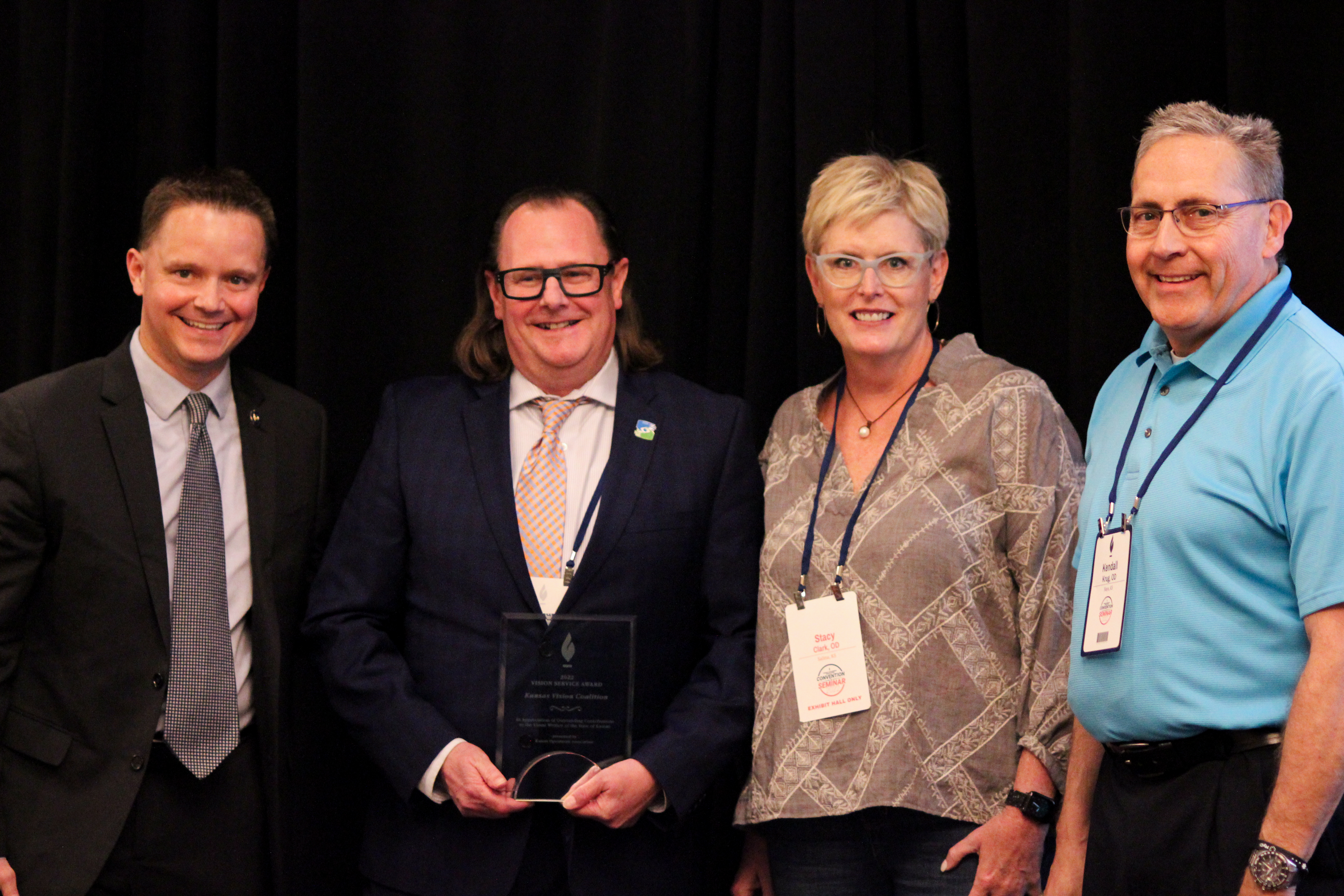 A group of people from the Kansas Vision Coalition posing for a photo after receiving an award