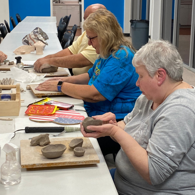 Envision Dallas students sitting at a table molding clay.