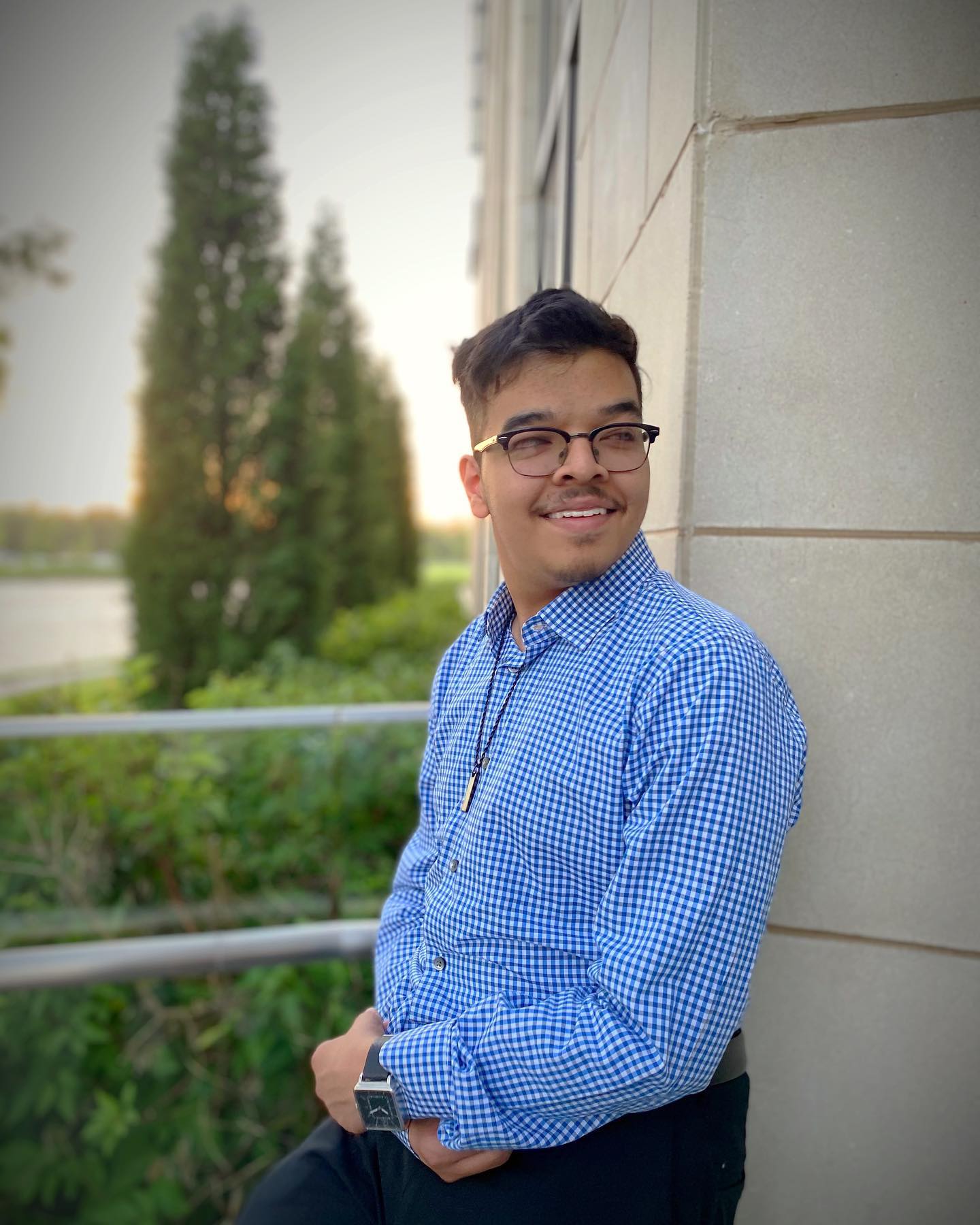 Hashim standing against a wall smiling.