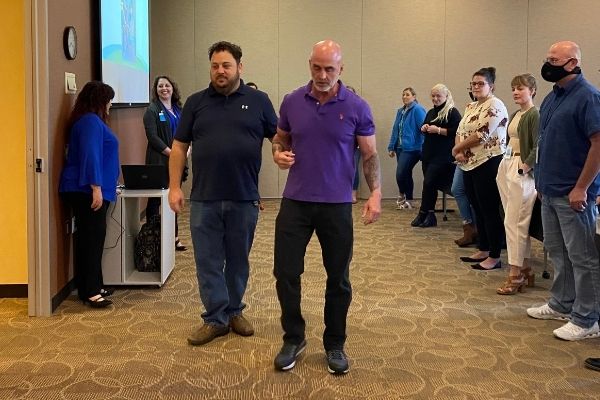 Ray Oddis demonstrates assisting a person who is blind or visually impaired to Delta Dental