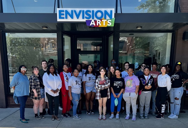 Large group of young adults standing in front of the envision arts gallery