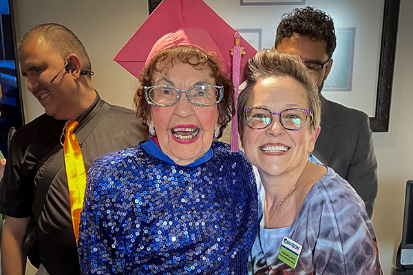 More Than a Program: How Envision Restores Confidence, Connection, and Purpose Joyful sister with her grad cap laughs with EVRC manager Jessica Clarke