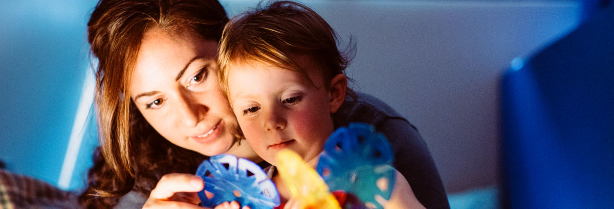Child care worker helps child who is blind. 