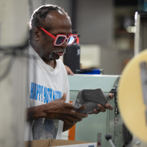 Man who is blind works at his station at Envision Industries.