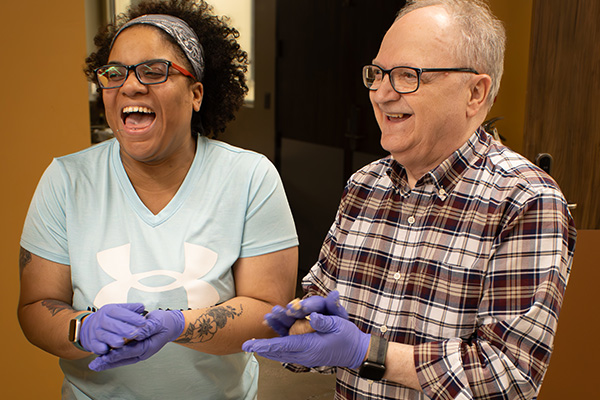 Confidence in the Kitchen: Envision and WSU Tech Partner to Deliver Accessible Culinary Training Niche course participants share a laugh while preparing meatballs during a hands-on cooking session.