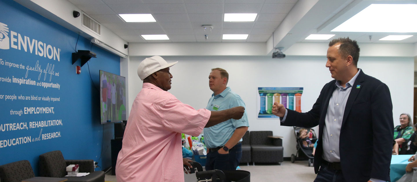 David Stupay, Managing Director, greets an Envision Dallas employee with a fist bump at the Employee Appreciation luncheon.