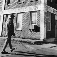 Man who is blind walks with his cane outside the building for the Kansas Foundation for the Blind.