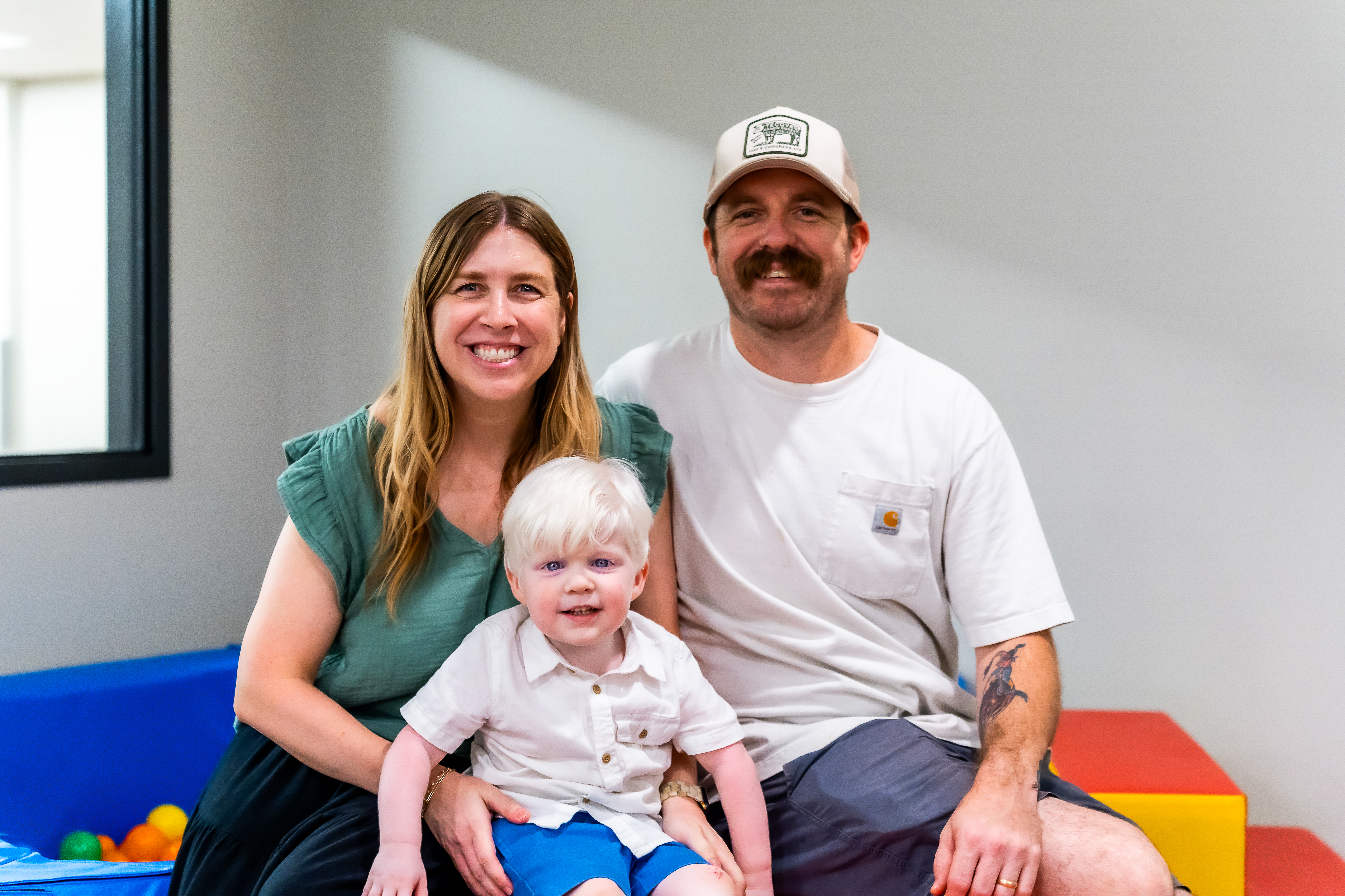 A young boy and his family smiling happily at the camera 