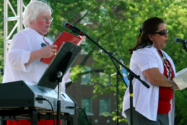 Regina performs with others at an outdoor concert.