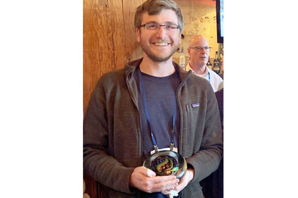 Garret Swan holding his Atwell Award at the 2019 Envision Conference.