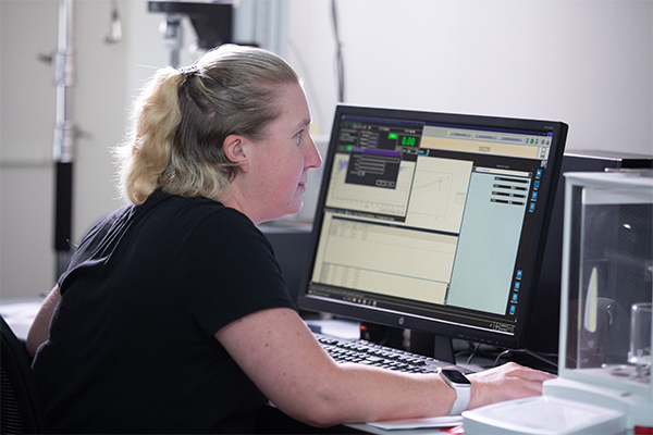 Woman who is visually impaired works at her computer processing data.