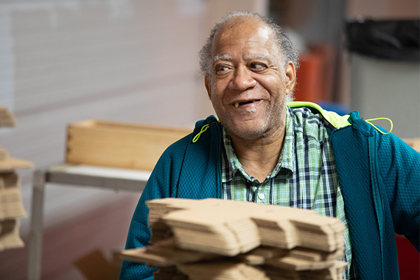Empowered by Choice: How Envision’s PRIDE Program Nurtures Independence Through Daily Skill-Building Norman smile as he folds boxes at the Envision PRIDE program.