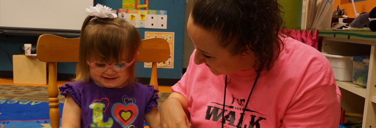 Young Dallas smiling at the ECDC with teacher