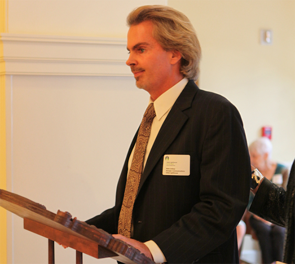 Blake Lindsay in a business suite standing at a podium