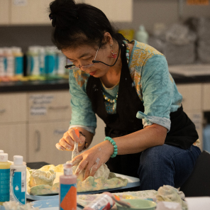 Woman who is visually impaired works on her sculpture at the Envision Arts studio.