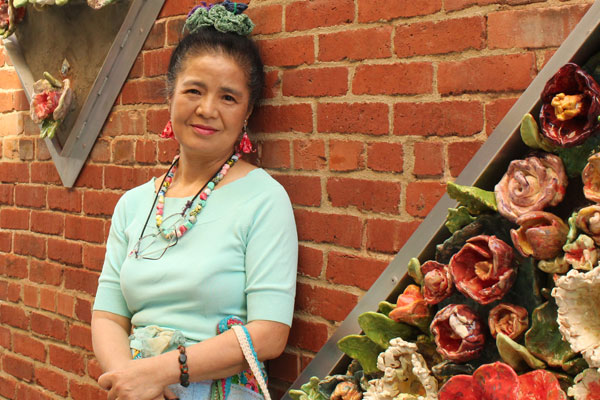 Tomiyo standing by her art creations at Gallery Alley